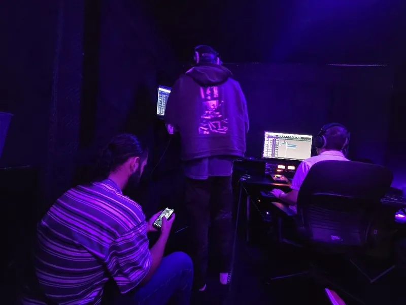 On the mic in the hoodie while the desk runs the session
