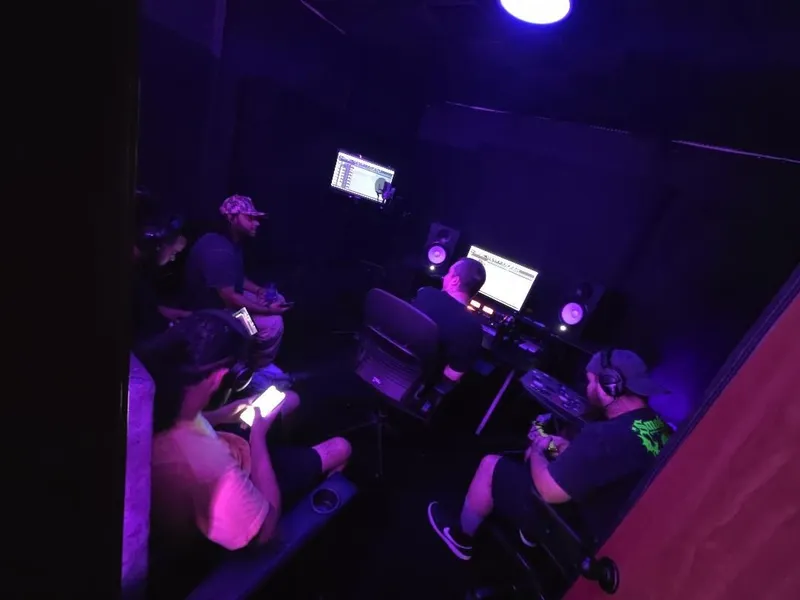 From the corner — the couch crew on their phones while the desk runs the session