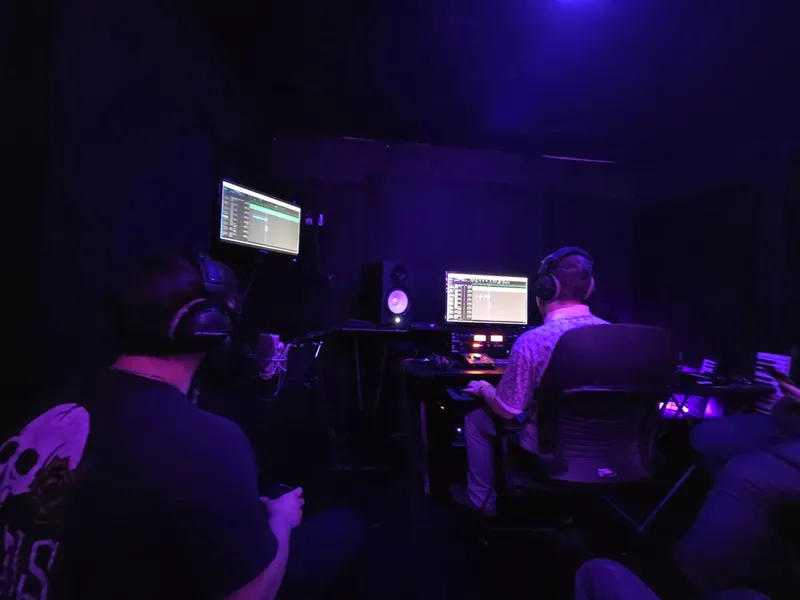 In headphones at the board, working the take