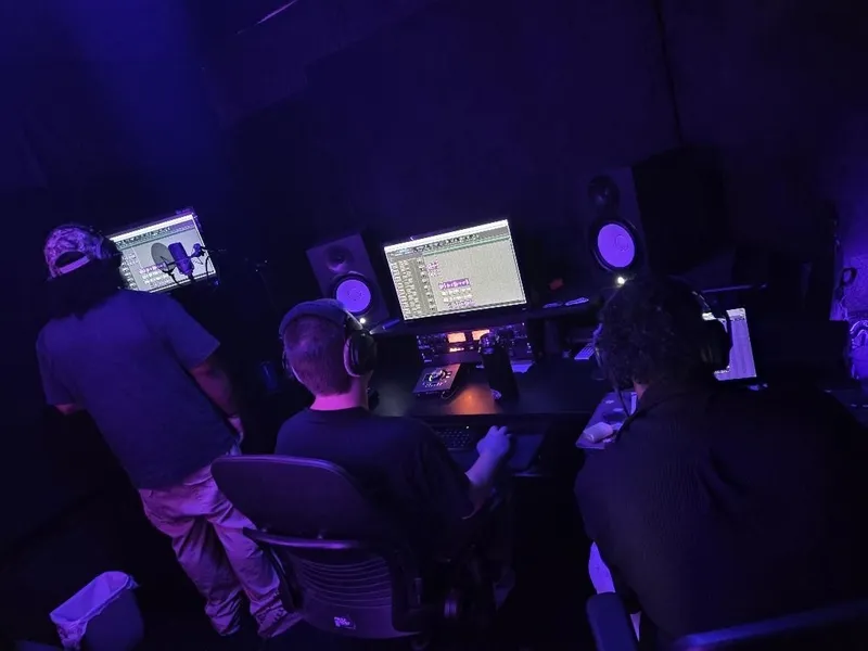Lining up the next take — one at the booth screen, two on the desks