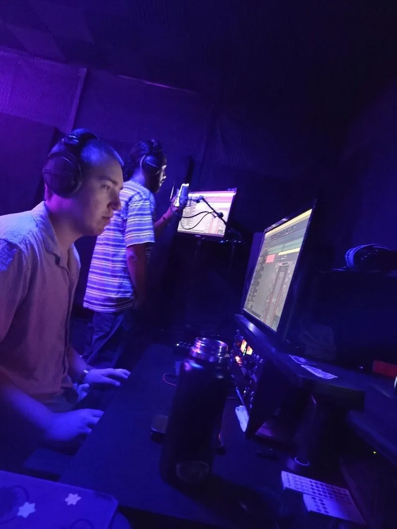 Eyes on the session at the desk, the artist at the mic right behind