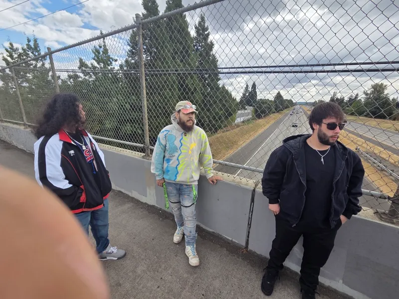 The crew on the bridge, freeway behind the fence