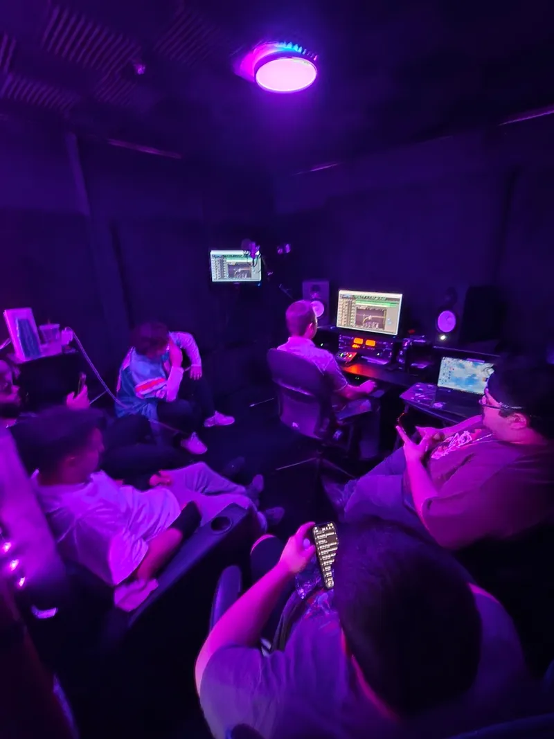 The room from the corner — phones out, verses going down