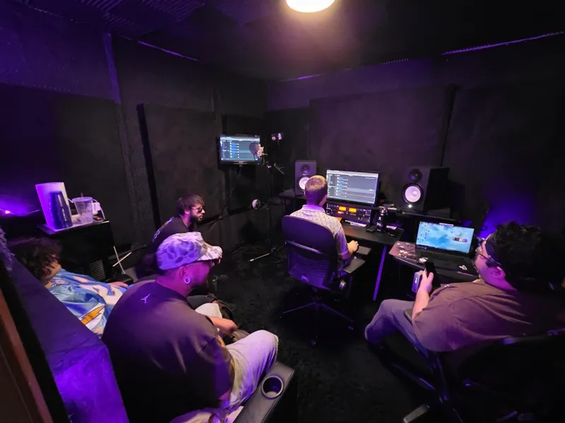 Early afternoon — the room gathered behind the desk, the session up on both screens